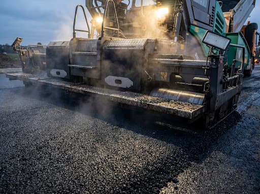 Close-up of a modern asphalt paver laying high-quality surface